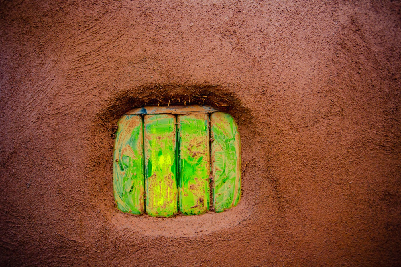 A glass-bottle window set into an earth wall