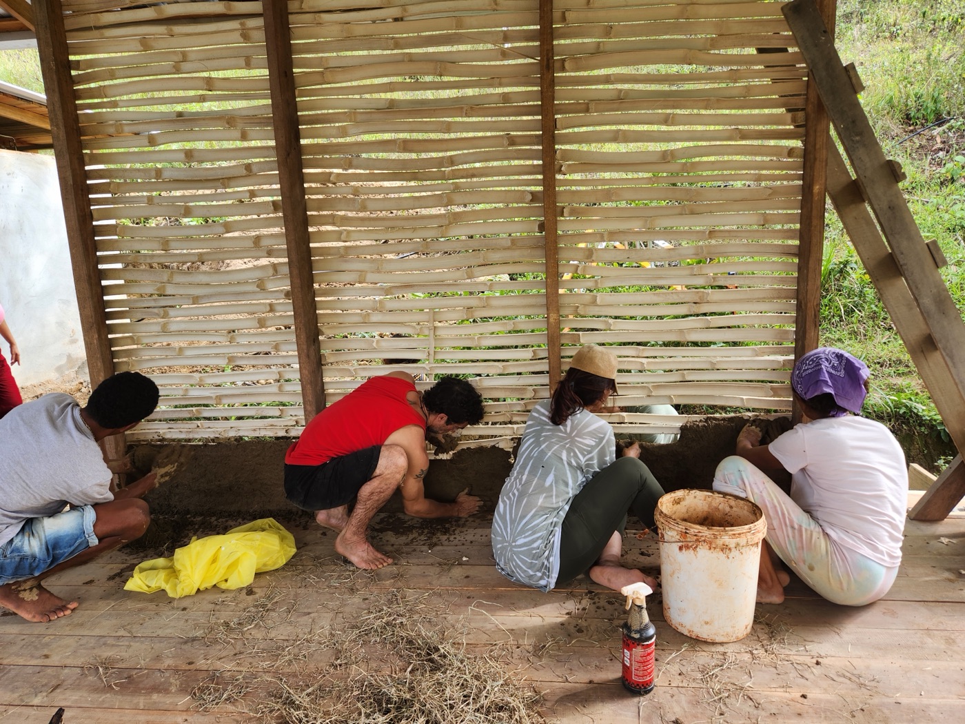 The group plastering an earth wall together