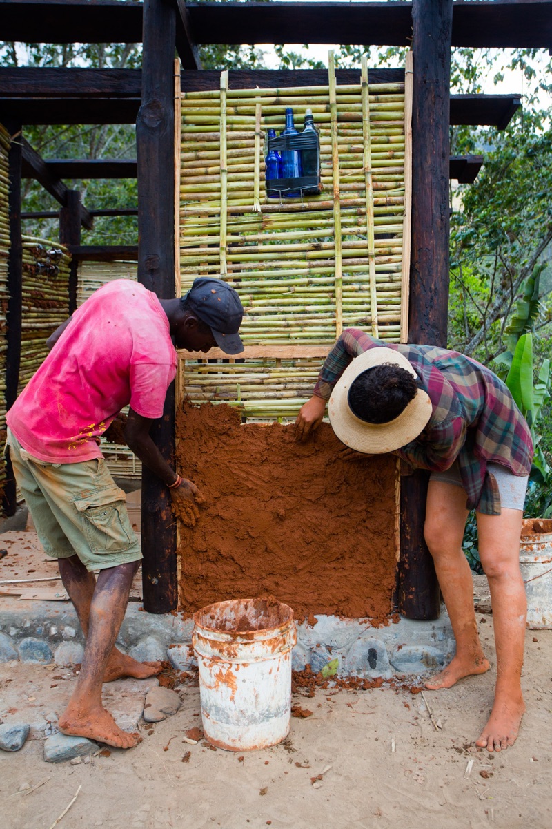 Applying earth plaster to a quincha wall by hand